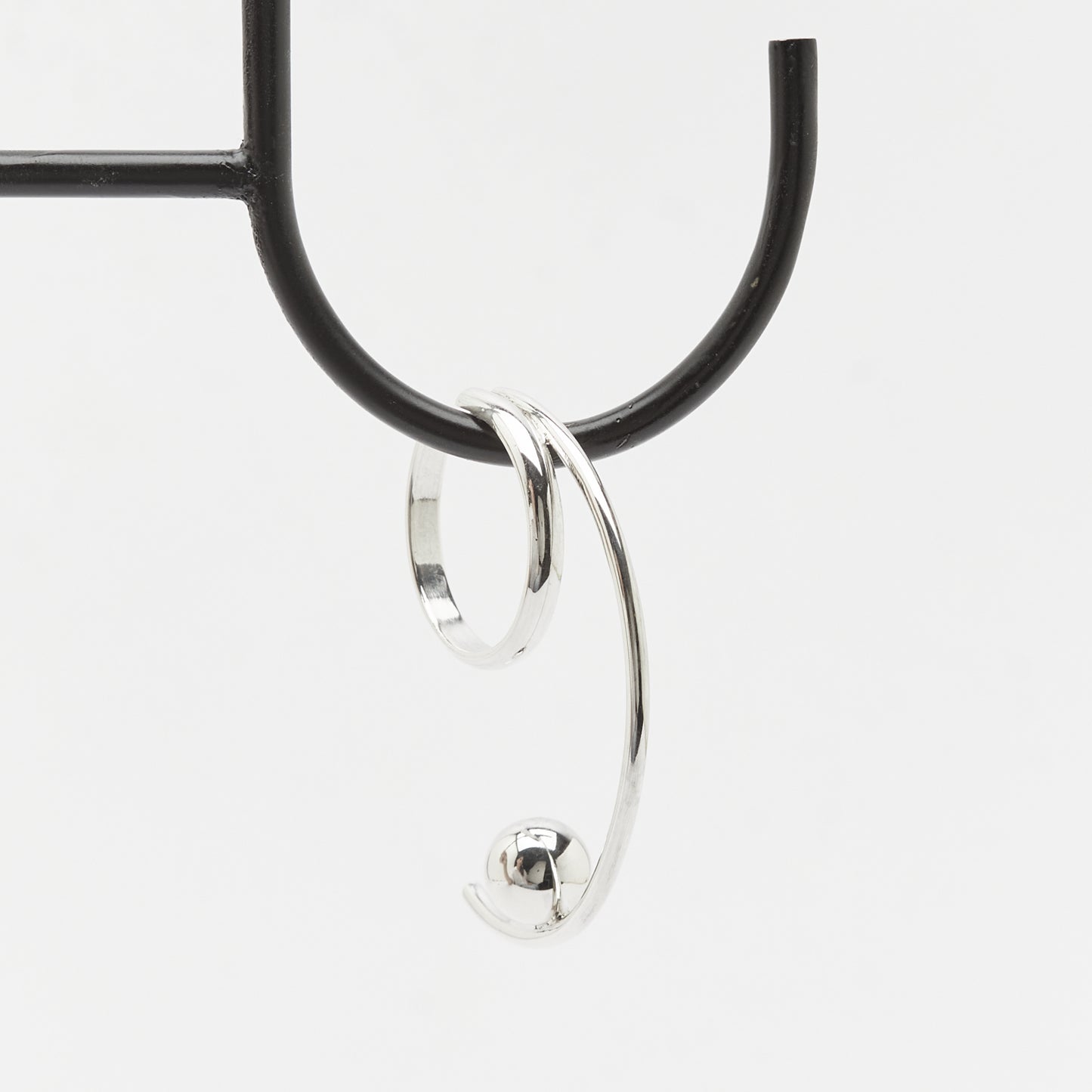 the beautiful curves of the TUNE IT silver earcuff hanging in balance, Unique handcrafted silver ear cuff – statement jewellery by AROE.