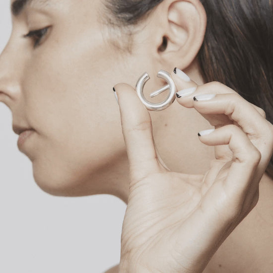 Stop motion showing how to wear and remove The Exception ear cuff – silver sculpture that wraps the ear in minimalist elegance. Unique handcrafted silver ear cuff – statement jewellery by AROE.