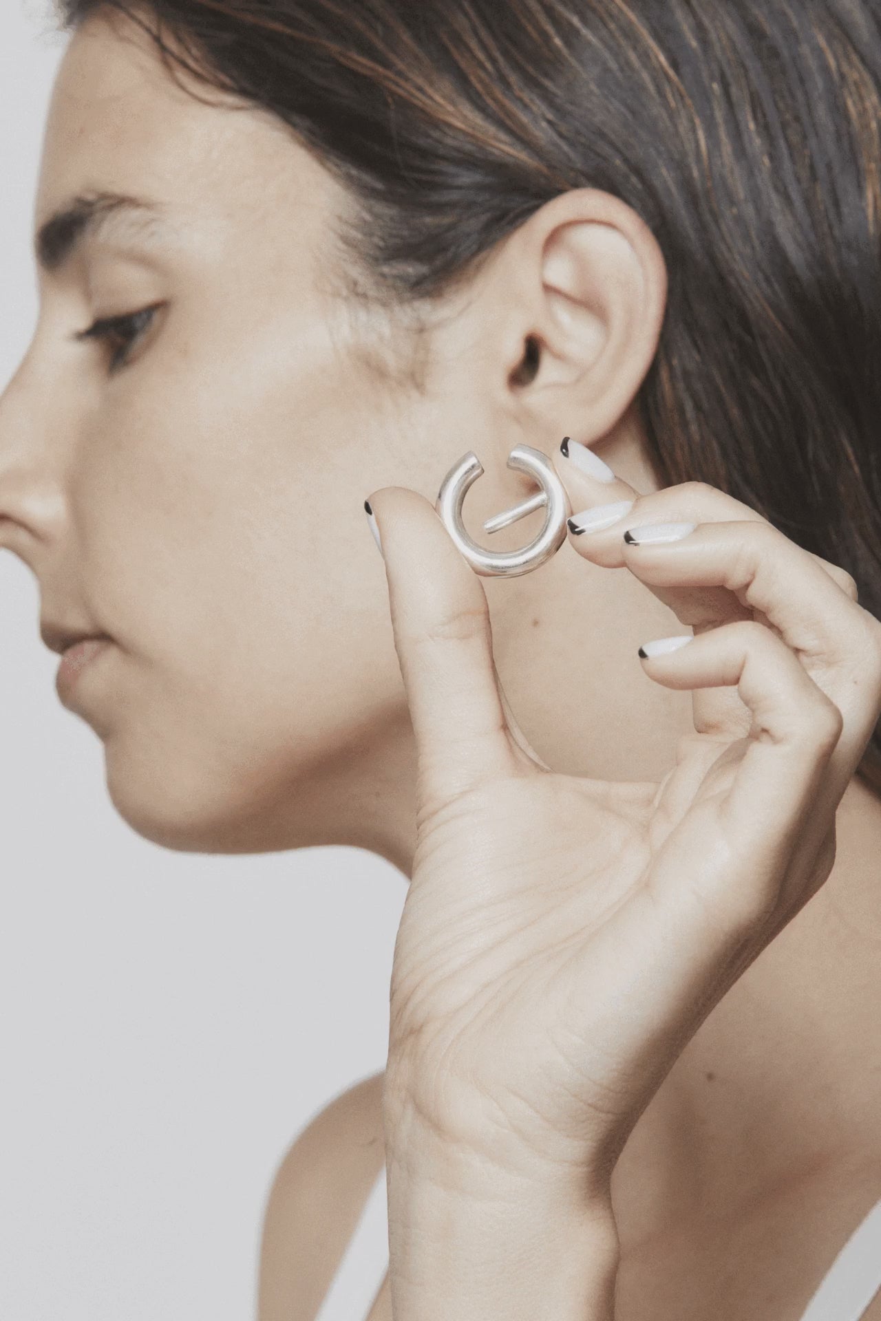 Stop motion showing how to wear and remove The Exception ear cuff – silver sculpture that wraps the ear in minimalist elegance. Unique handcrafted silver ear cuff – statement jewellery by AROE.