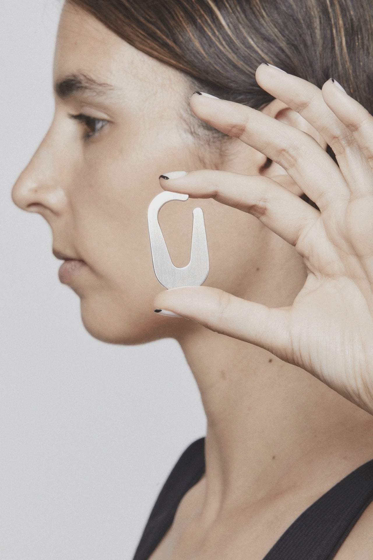 Unmarked Appeal earcuff in stop motion – showing a quiet ritual of adornment with a silver design that subtly completes the ear form BY AROE