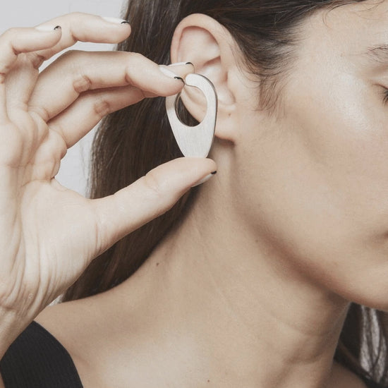 Stop motion showing how to place and remove the Empty Composition ear cuff – a minimalist silver piece playing with presence and silence around the ear Unique handcrafted silver ear cuff – statement jewellery by AROE.

