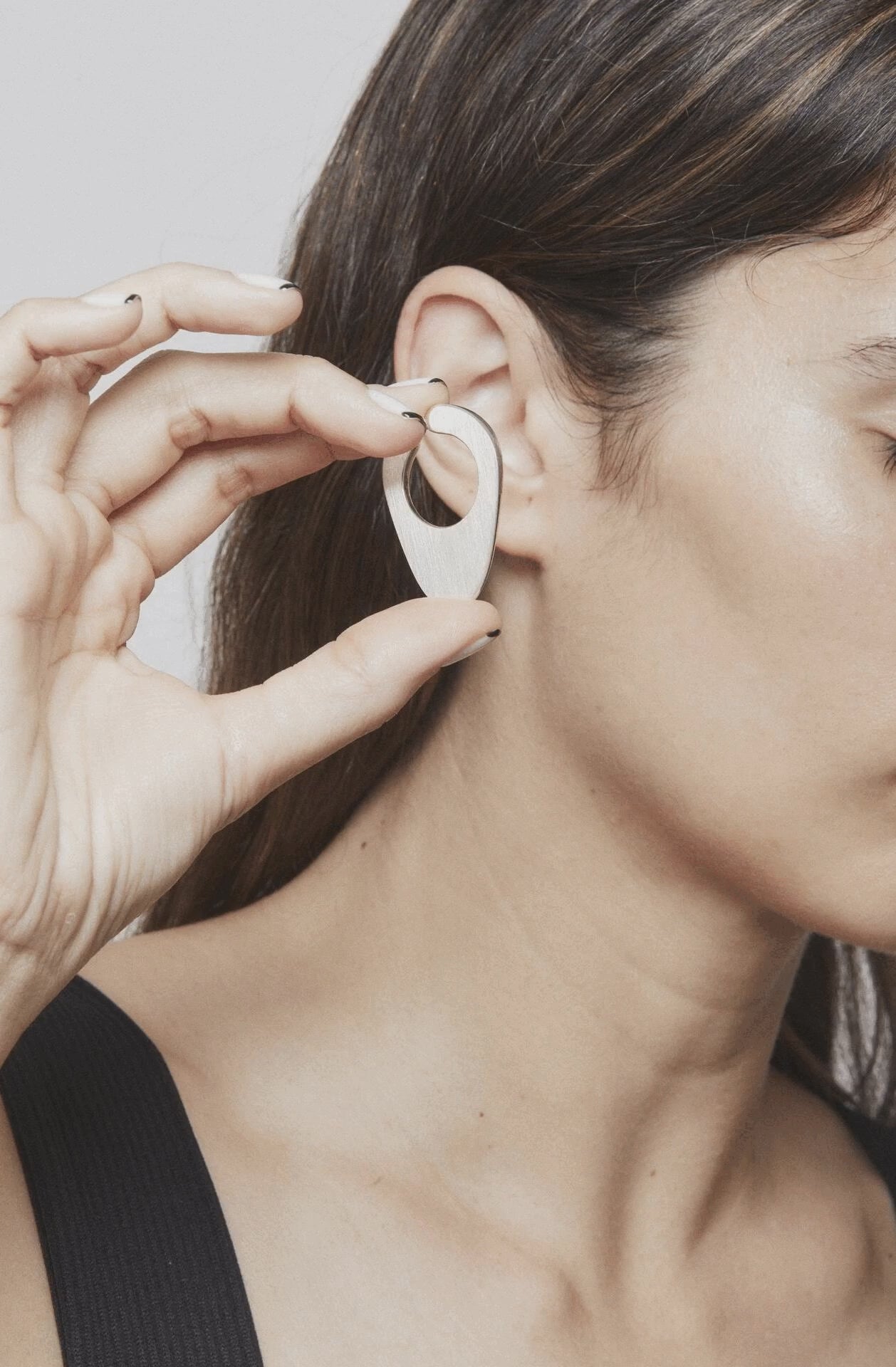 Stop motion showing how to place and remove the Empty Composition ear cuff – a minimalist silver piece playing with presence and silence around the ear Unique handcrafted silver ear cuff – statement jewellery by AROE.

